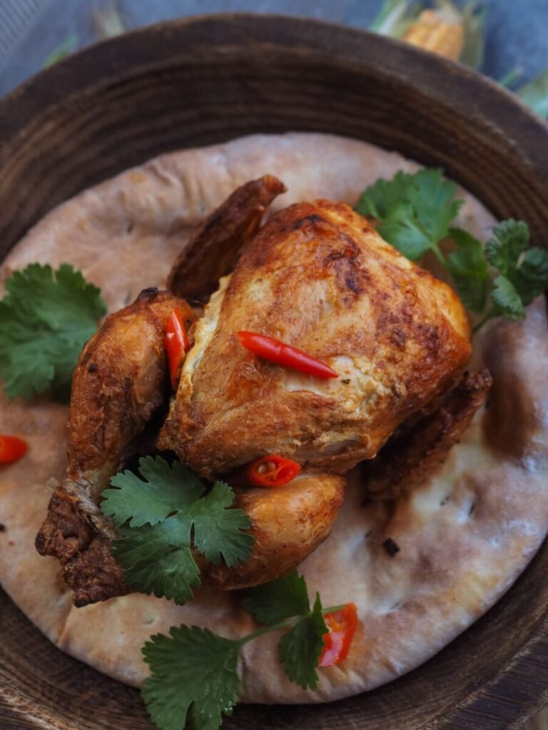 Mouthwatering roasted chicken atop flatbread garnished with cilantro and chili.