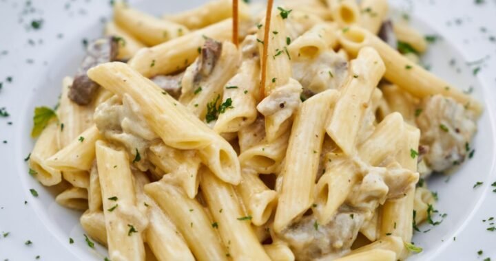 Close-up of creamy pasta with herbs, offering a delicious Italian meal.