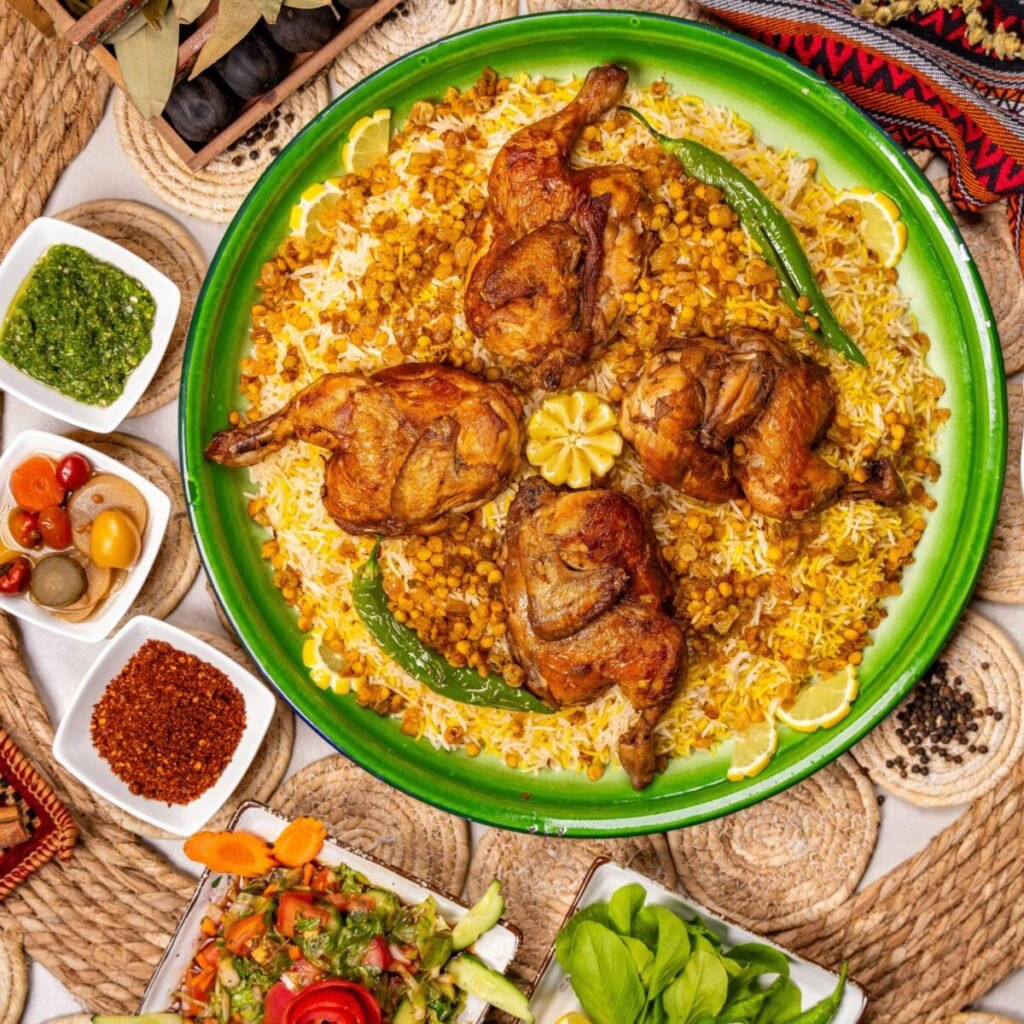 Savory roasted chicken on a bed of rice with lentils, accented by spicy and fresh green sides.