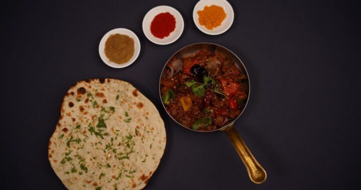 Top view of lachha bread, spices, and Indian curry in a pan. Perfect for food photography.