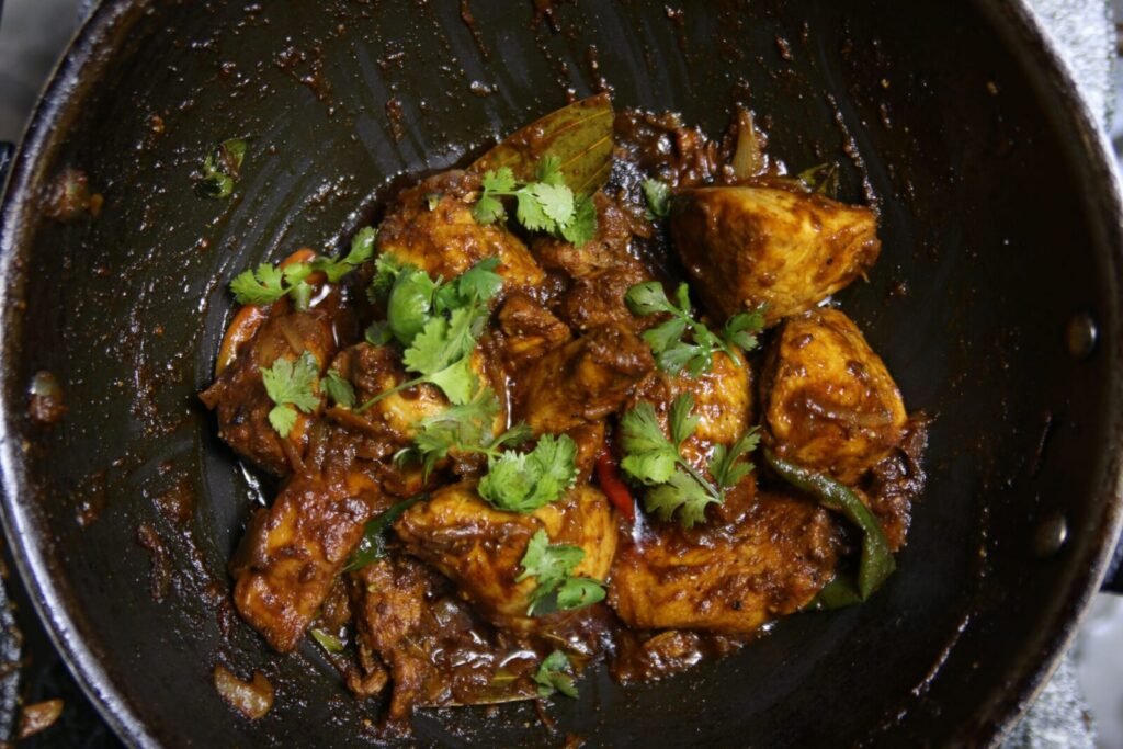 Close-up of spicy Indian chicken curry garnished with cilantro.