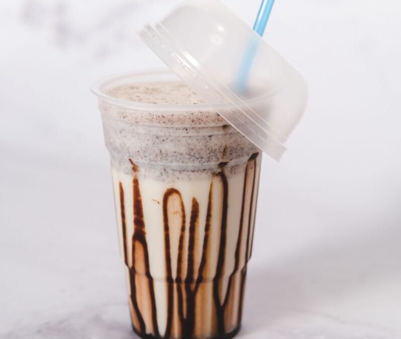 Delicious iced chocolate shake in a clear plastic cup with a straw, perfect for summer cravings.