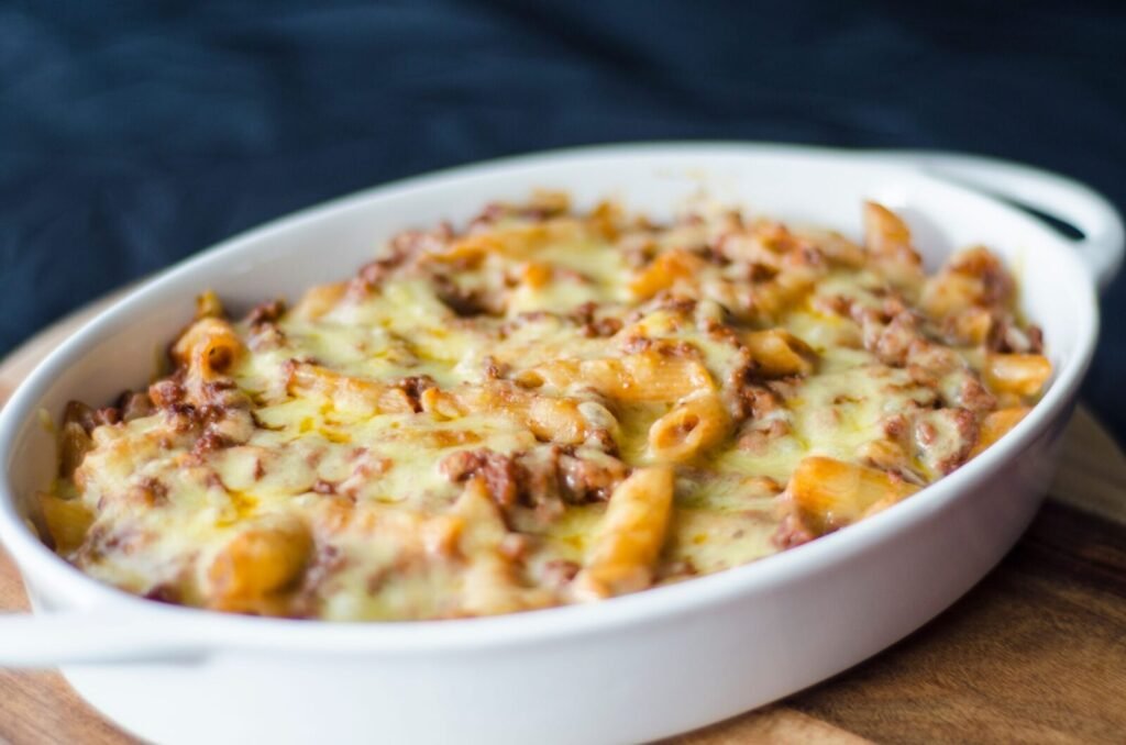 Close-up of a homemade baked macaroni and cheese in a white dish. Perfect comfort food for lunch or dinner.