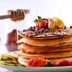 a stack of pancakes with fruit on top